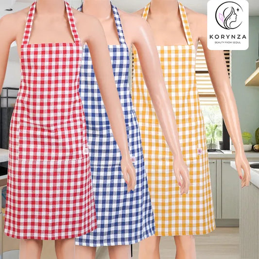 Three halter-style bib aprons with gingham checks are shown on mannequins in a kitchen setting. The aprons are red and white, blue and white, and yellow and white.